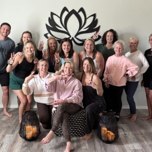 A joyful group of women posing together in front of a lotus wall decal.